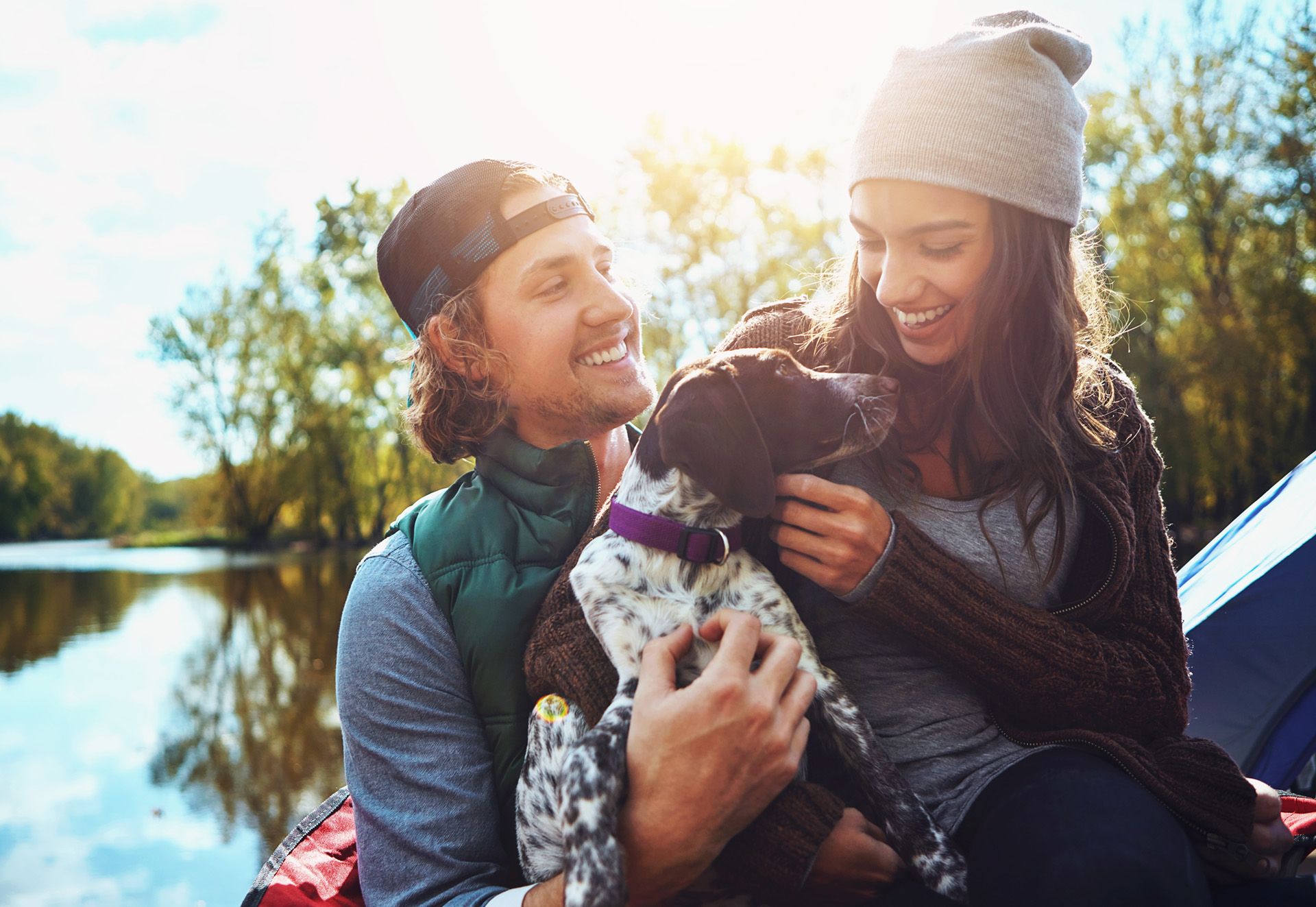 Couple, camping and lake in nature with dog